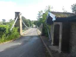 View of Whorlton Suspension Bridge and toll house in Whorlton, Teesdale from far end of bridge July 2016